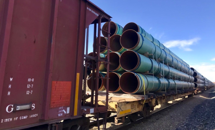 An image of a train hauling large pipes to be used for oil and gas pipelines.