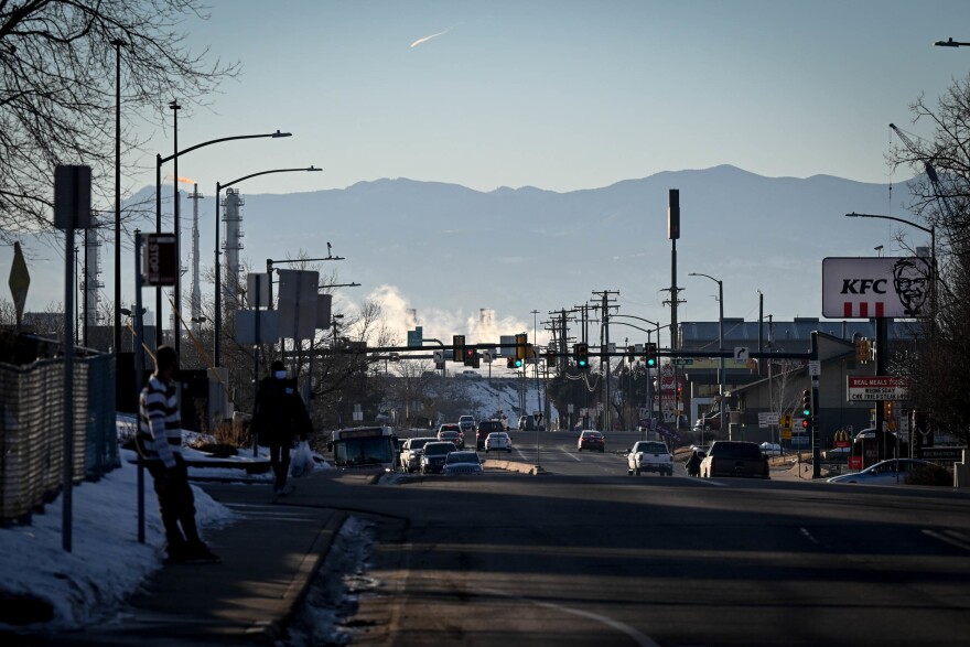 The hustle and bustle of Commerce City, Colo., unfolds in the foreground as Colorado's Rocky Mountains stand tall in the distance.