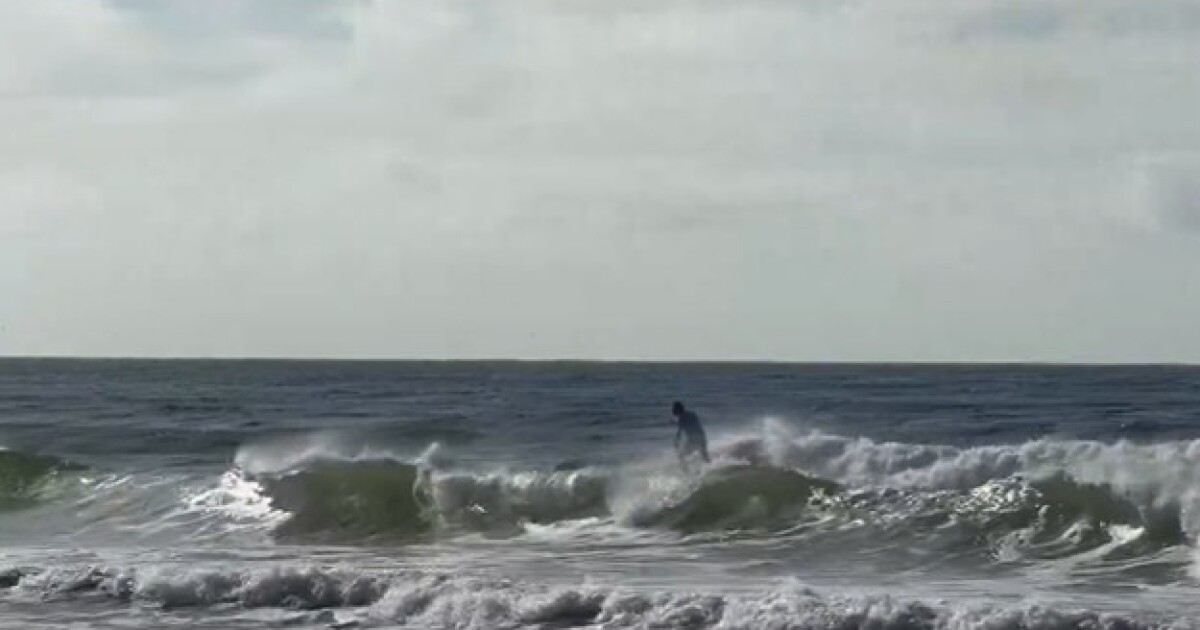 Photo of a surfer taking advantage of conditions produced by Tropical Storm Bertha in the Gulf.