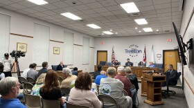 People sit in folding chairs facing the Trenton Planning Commission.