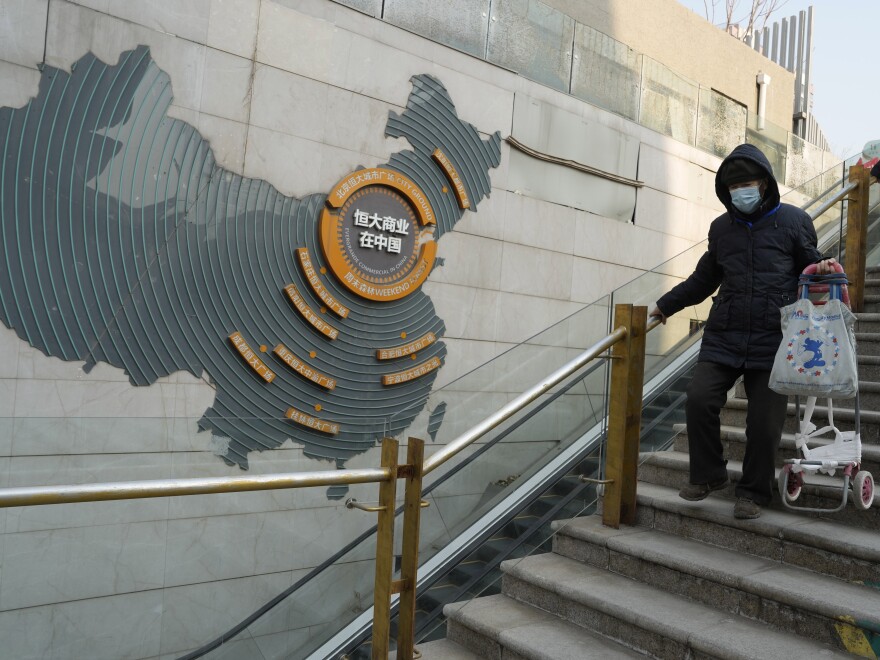 Residents walk through a partially shuttered Evergrande commercial complex in Beijing, Monday, Jan. 29, 2024.