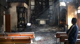 An Indian man on Dec. 2 surveys the damage following a fire a day earlier inside St. Sebastian's Church in New Delhi. This was the most serious of several incidents at churches since December. On a visit to India last week, President Obama urged Indians to respect religious freedom.