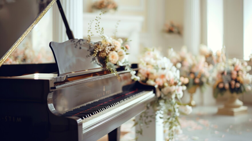 Design an image of a grand piano at a wedding venue, beautifully decorated with flowers and ribbons.