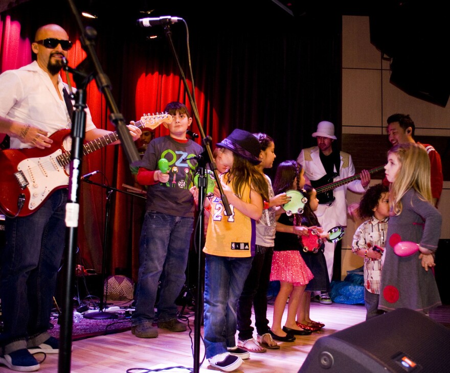 Ozomatli invites kids onstage for a performance.