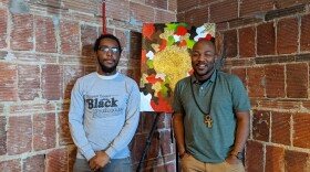Paul Wellington and Rick Banks, creators of the MKE Black app, stand before art of Africa on display at the Sherman Phoenix. 