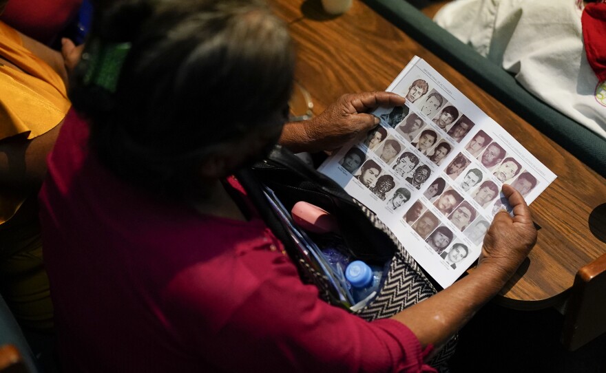 Photos of missing people fill a report by the Guerrero state government during the presentation of a new report about the country’s 1965-1990 “dirty war” by Mexico's governmental Truth Commission in Mexico City, Friday, Aug. 16, 2024. (AP Photo/Eduardo Verdugo)