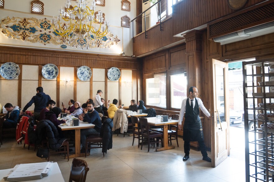 A server opens the door for customers at Imam Cagdas.