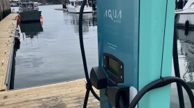 An Aqua Superpower level 3 charger installed on Wrights Wharf in Portland. The Heron, a 28-foot custom electric aquaculture boat is docked in the ba