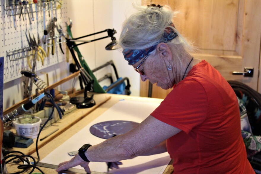 Mary Lynn Munro works on a new stained glass piece for the kitchen.