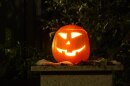 A carved pumpkin sits outside. 