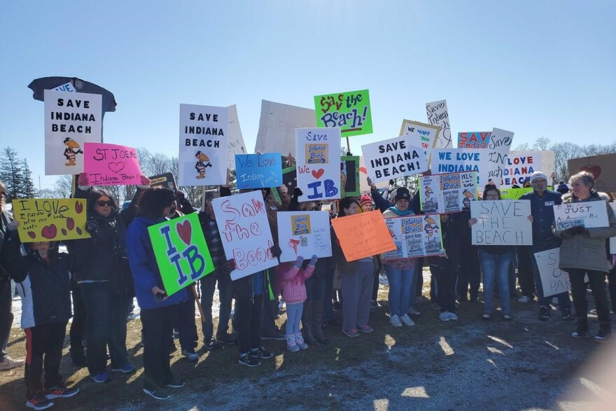 Attendees at Saturday's rally hold signs in support of saving Indiana Beach.