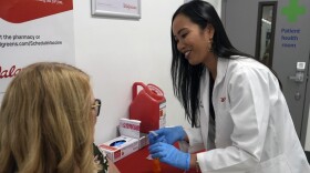 Anh Nguyen prepares to administer a COVID-19 vaccine for Kelly Vazquez at a pharmacy in New York, Tuesday, Sept. 24, 2024. (AP Photo/Mary Conlon)