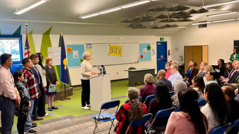 Oregon Gov. Tina Kotek at a podium in a classroom.