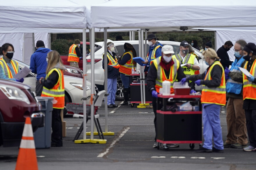 Wake County Health Department workers along with nurses and volunteers from area hospitals and emergency services are seen during a drive through COVID mass vaccination event at PNC arena in Raleigh, N.C., Thursday, Feb. 11, 2021. Since North Carolina began administering the vaccine in December, more than 1 million people have gotten their first doses. 