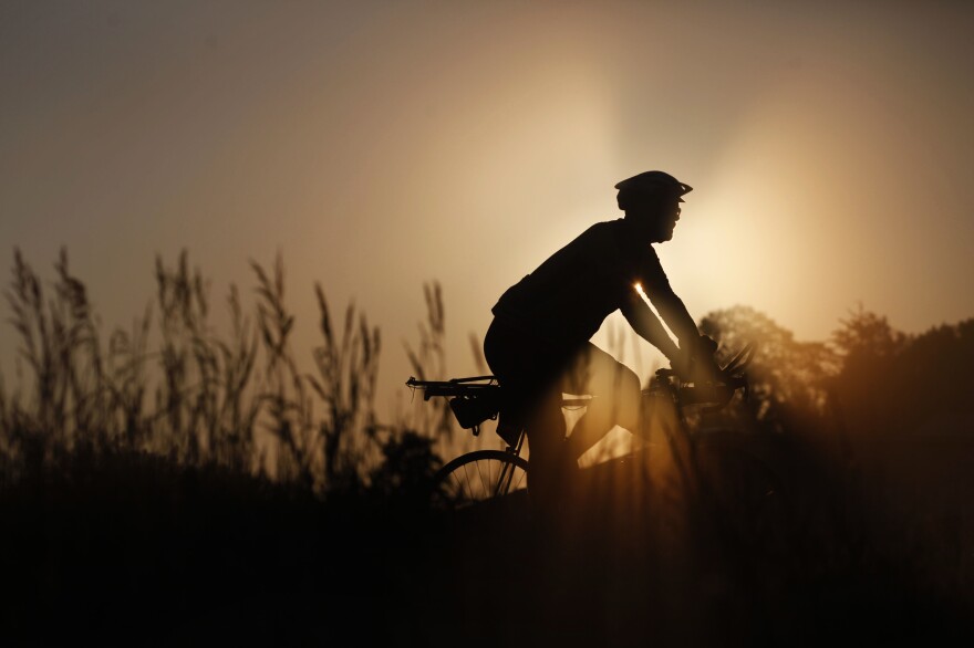 A rider makes their way along RAGBRAI's route on a foggy morning Wednesday, July 28, outside of Emmetsburg, Iowa, on Day 4 of the annual recreational bike ride across the state of Iowa.