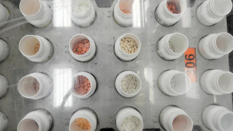 Bottles of prescription pills go through an automated packaging machine in a pharmacy plant. The Supreme Court on Tuesday hears a case that considers whether pharmacies knowingly overcharged Medicare and Medicaid under the False Claims Act.