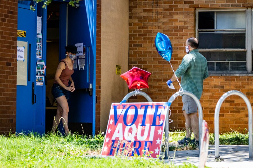 Residents wear masks to vote in the runoff elections, at Joslin Elementary School last month. 