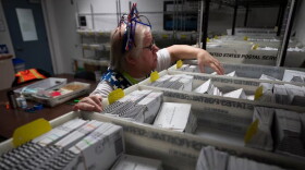 FILE - Election worker Wendy Wimer looks through vote-by-mail ballots for the presidential primary election, March 12, 2024, at the Clark County Elections Office in Vancouver, Wash.