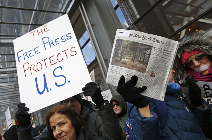 Protesters hold signs during a show of solidarity with the press in front of The New York Times building, Sunday, Feb. 26, 2017, in New York.