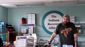 Scott Pietrovich stands behind the front desk of the Indiana Recovery Alliance. Supplies are stocked behind him.