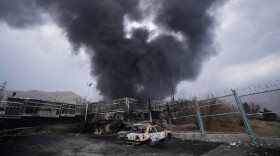 FILE - A thick plume of smoke rises from an oil storage facility hit by a U.S.-Israeli strike in Tehran, Iran, March 8, 2026. 