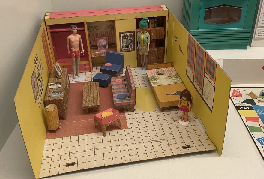 A cardboard Barbie doll house from the 1960s with Barbie, Ken, and Skipper dolls.