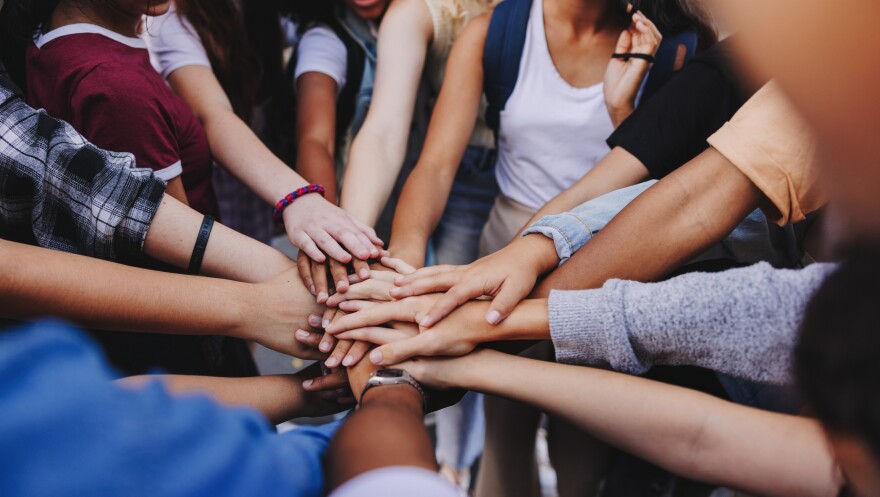 Multicultural teenagers putting their hands together in a huddle. Group of unrecognizable young people expressing their unity and teamwork.