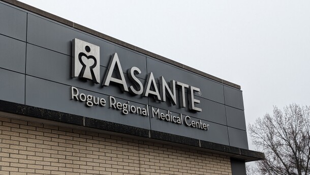 A metal sign on the corner of a building outside that reads, "Asante Rogue Regional Medical Center"