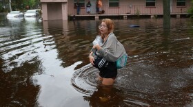 Makatla Ritchter wades through flood waters after having to evacuate her home when the flood waters from Hurricane Idalia inundated it on August 30, 2023 in Tarpon Springs, Florida.