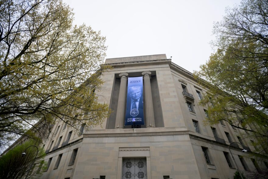 A government building with a blue banner bearing the face of Donald Trump