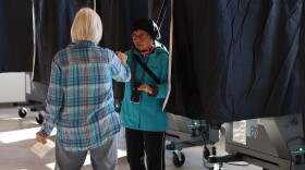 Niesdri Welsh gets a sticker after casting her ballot Tuesday, Nov. 4, 2025, at the Brighton Winter Farmers Market Barn.