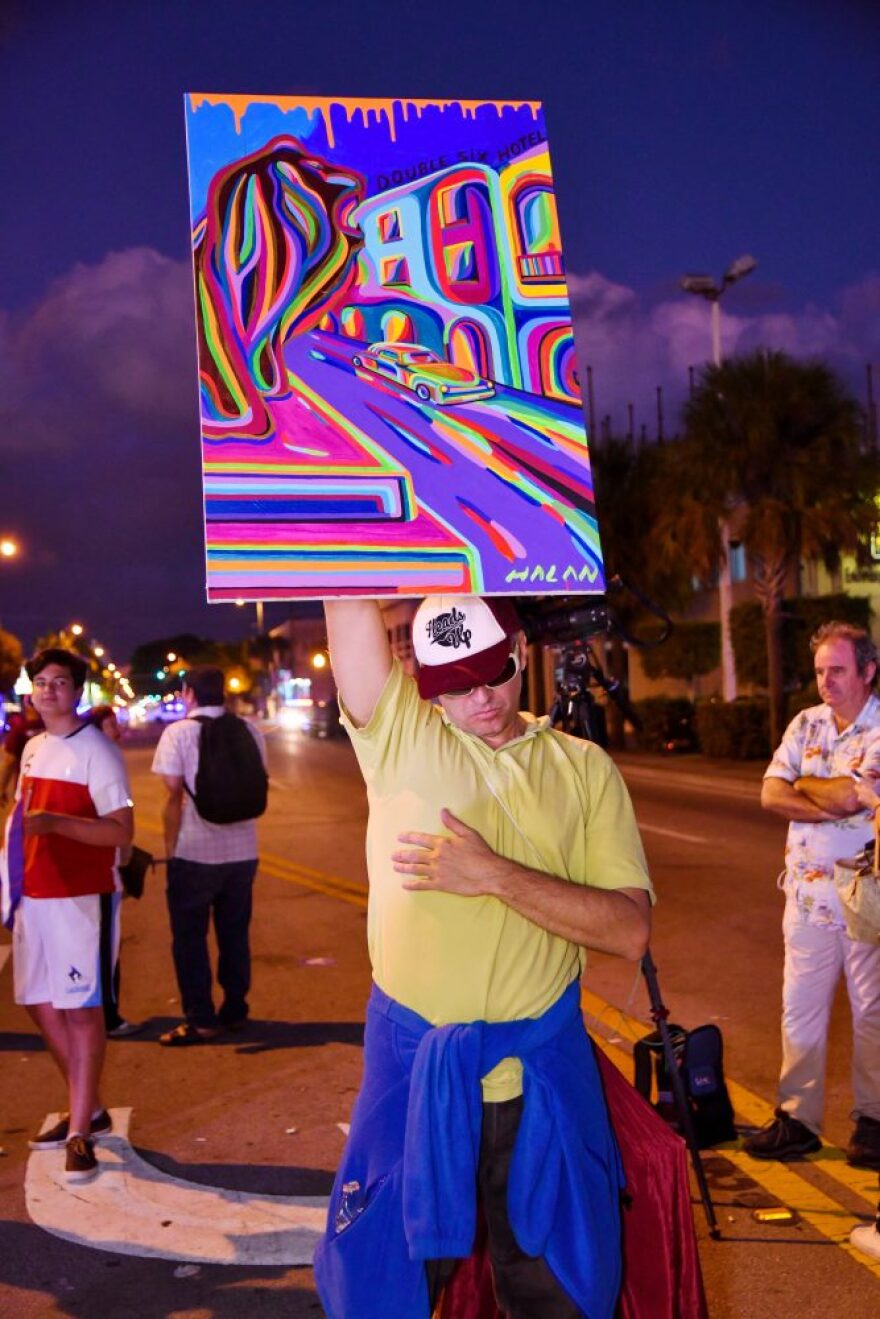 Halan Lopez holds up a painting representing the freedom of Cuba. He described himself as the “Statue of Liberty” for Cuba and said he was making a “small sacrifice for the freedom of Cuba.” (Grace King/ WUFT News)