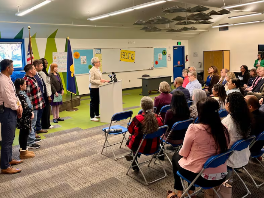 Oregon Gov. Tina Kotek at a podium in a classroom.