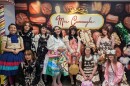 A group of people in colorful dresses, with large, poofy skirts and sleeves. 