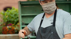 A staff member at The Regional restaurant in Fort Collins uncorks a bottle of wine.