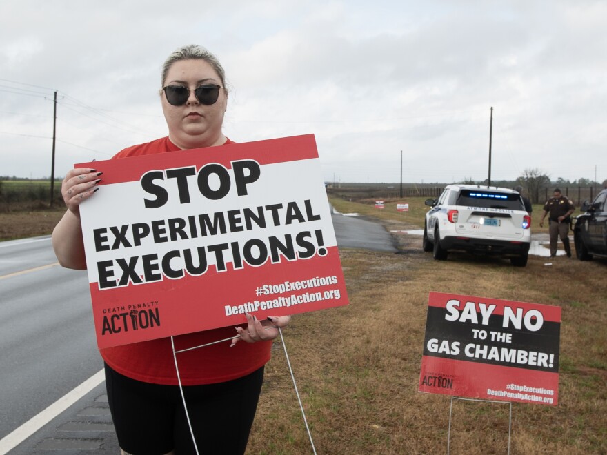 Alli Sullivan holds a sign protesting the use of nitrogen gas in executions on the road leading to Holman Correctional Facility in Atmore, Ala. She is on the communications team at Death Penalty Action, an organization that seeks to stop executions and end the death penalty.