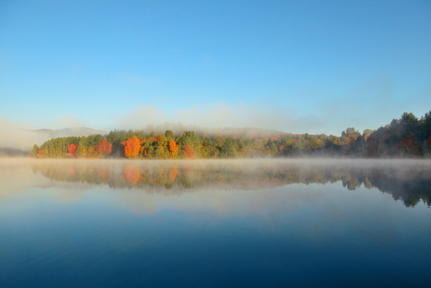 A lake with morning fog in fall.
