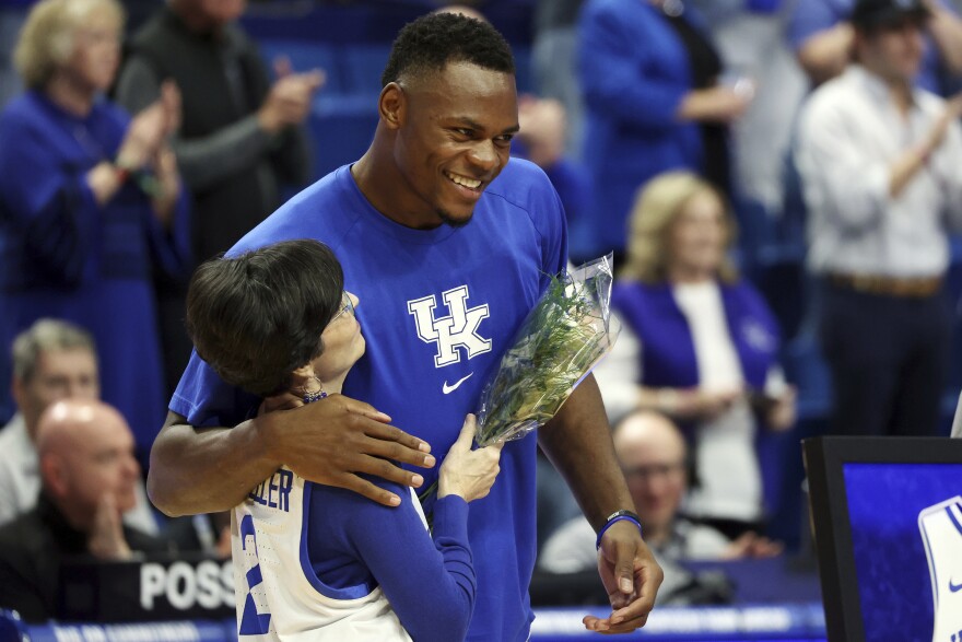 Kentucky's Oscar Tshiebwe, right, hugs Ellen Calipari, wife of head coach John Calipari during senior day ceremonies before an NCAA college basketball game against Vanderbilt in Lexington, Ky., Wednesday, March 1, 2023. (AP Photo/James Crisp)
