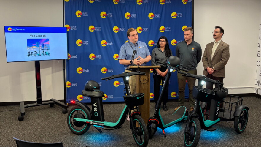 Max Gilles (left) stands with his team as the city announces its transition from Lime to Veo as Grand Rapids' micromobility vendor.