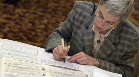 A job-seeker fills out an application at a senior job fair in Palatine, Ill., in 2003. Many older workers, however, have been pushed to draw on their Social Security benefits due to high levels of unemployment.