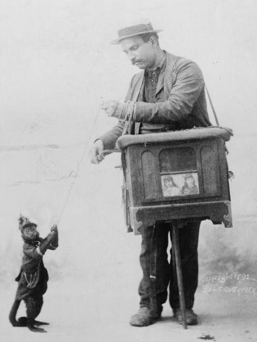 An organ grinder and his monkey, postcard dated 1892.