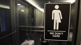 In this May 12, 2016, file photo, gender free sign hangs outside a restroom at 21c Museum Hotel in Durham, N.C.