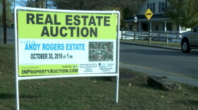 A sign advertising an auction for the 16 properties owned by the late Andy Rogers