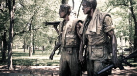 Statue of three soldiers staring in the same direction with one pointing a rifle