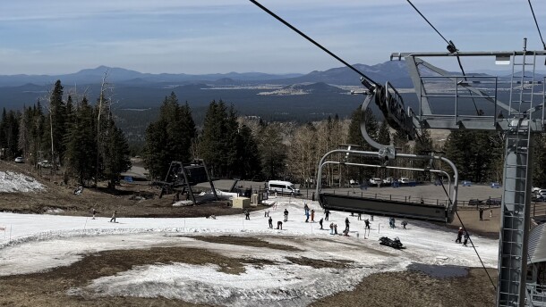 Skiers navigate a thin strip of snow at the Arizona Snowbowl near Flagstaff, Arizona on March 16, 2026. A hot, dry winter left mountains in the Colorado River Basin bereft of snow, which will strain the nation's largest reservoirs.
