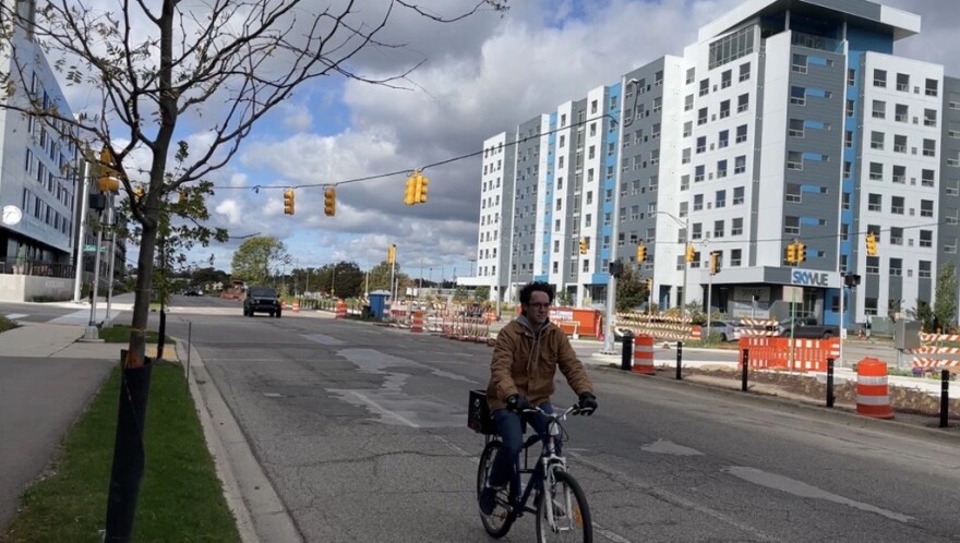 A biker rides on a street of East Lansing.