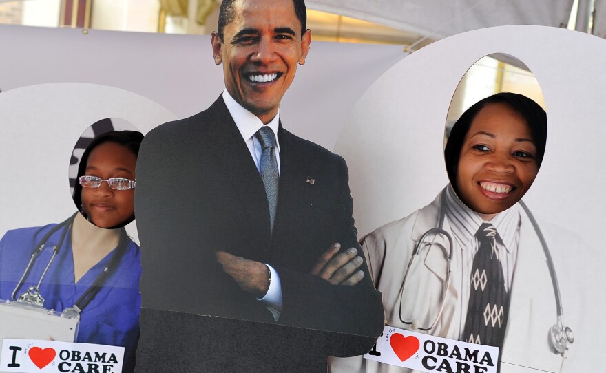 Two girls pose for a picture with a cardboard cut-out of President Obama in a tent defending "Obamacare" in Charlotte, N.C., on Sept. 3, 2012.