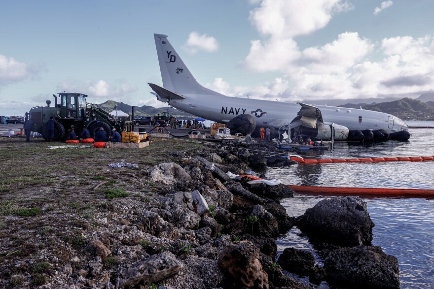 U.S. Navy use inflatable salvage roller bags to extract the U.S. Navy P-8A Poseidon from waters just off the runway at Marine Corps Air Station Kaneohe Bay