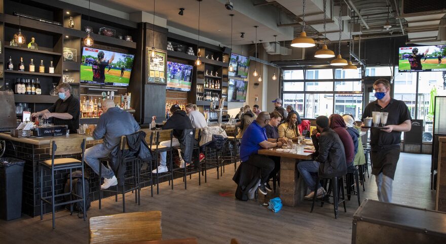 Customers gather at a bar and eatery in Boston on Saturday, May 29, 2021, the first day the majority of pandemic restrictions lifted on businesses in Massachusetts.