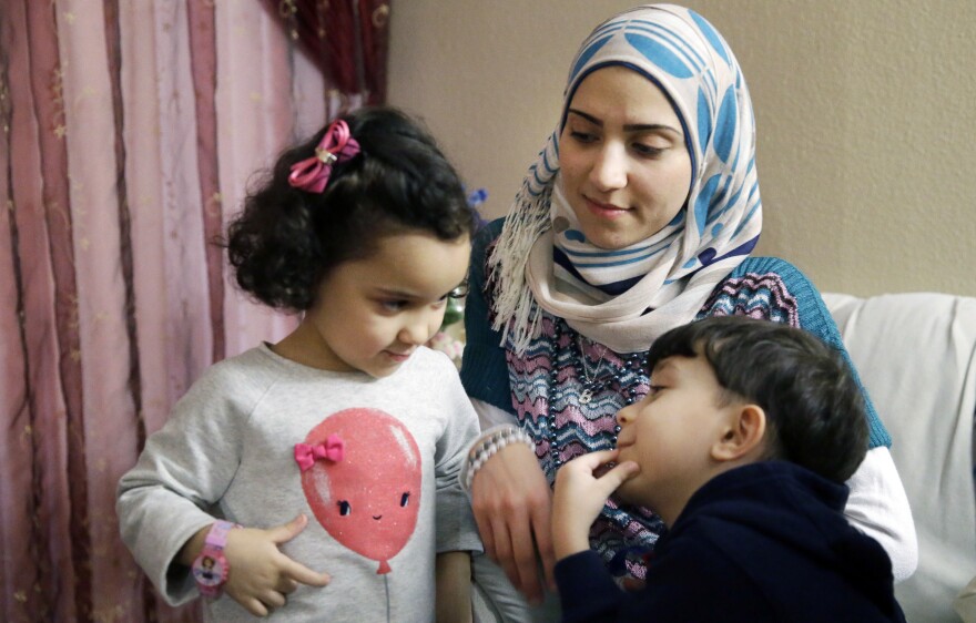 Syrian refugee Maryam al-Jaddou sits with her children Maria (left) and Hasan in their apartment in Dallas. Jaddou says she decided to leave Syria in 2012 after her family's home in Homs was bombed and there was nowhere safe left to live.